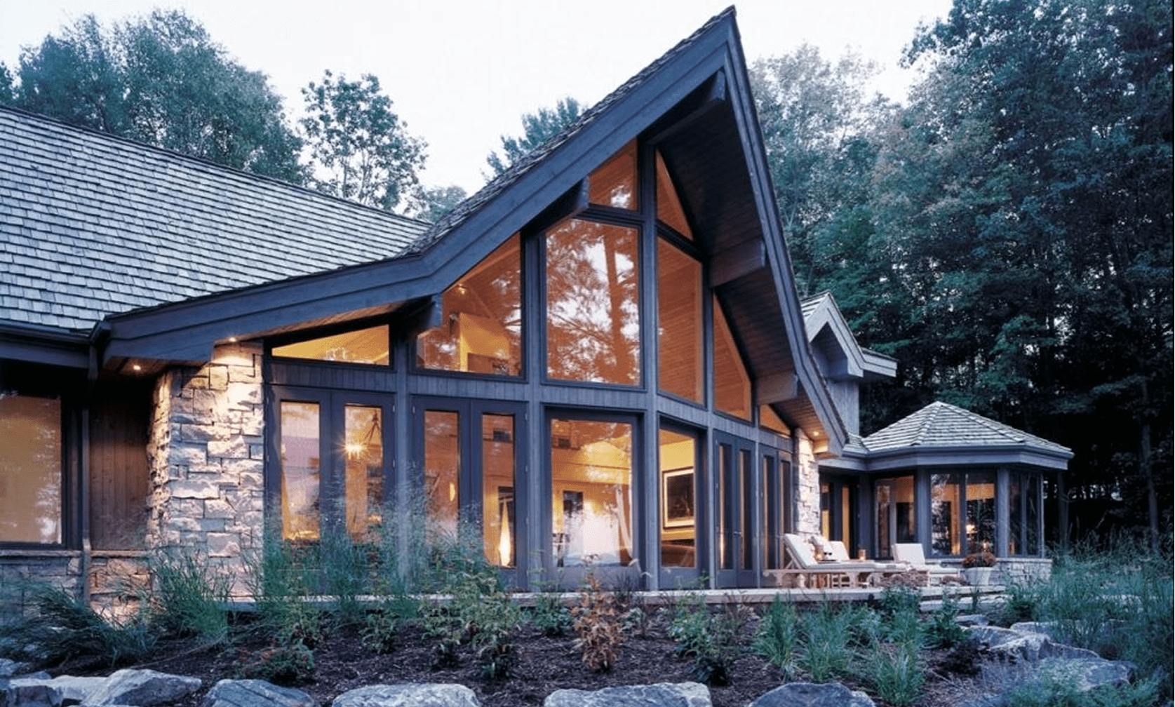 Modern house with large windows and trees.