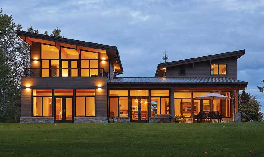 Modern house with large windows at dusk.