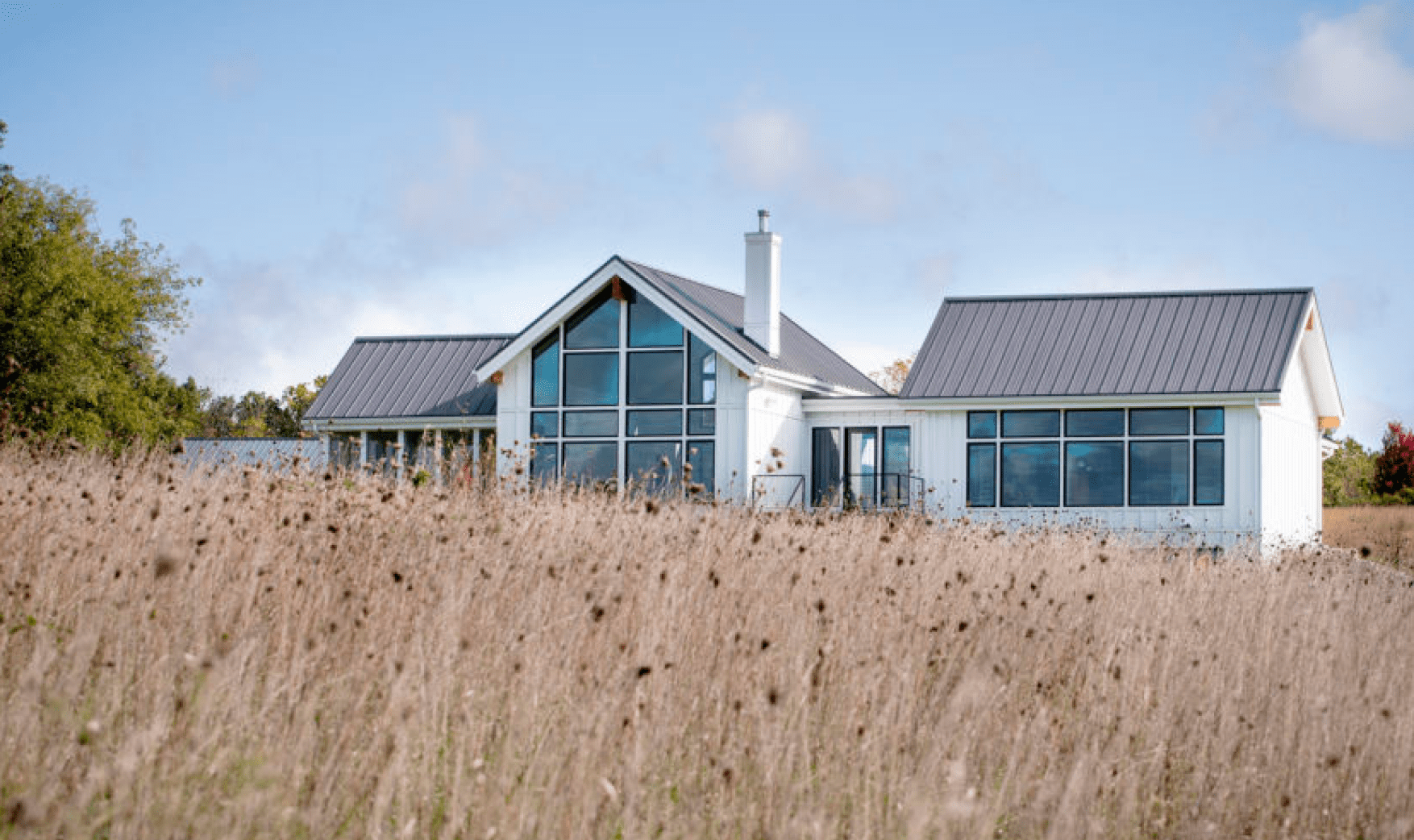 Modern house surrounded by grass field.
