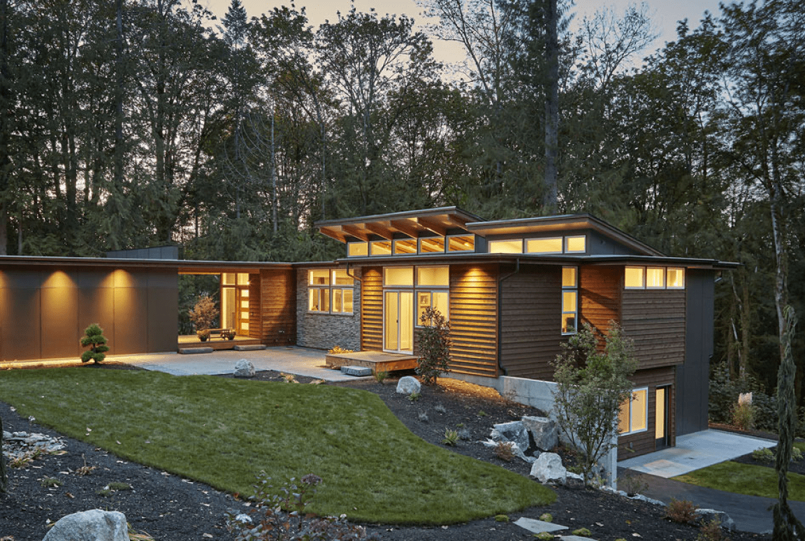 Modern house with large windows in woods.