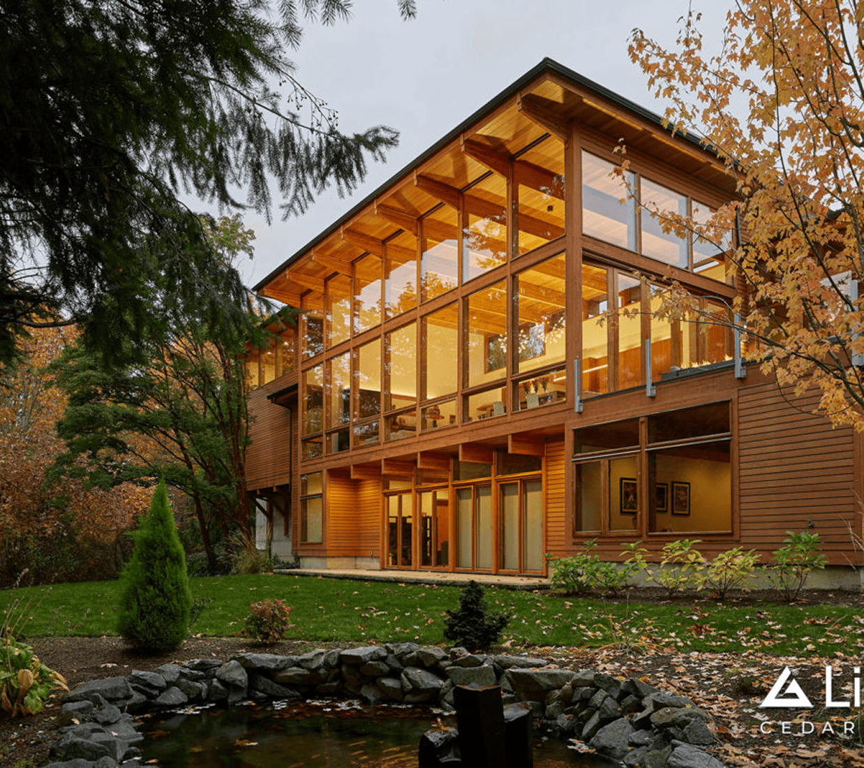 Modern wooden building with glass windows, pond.